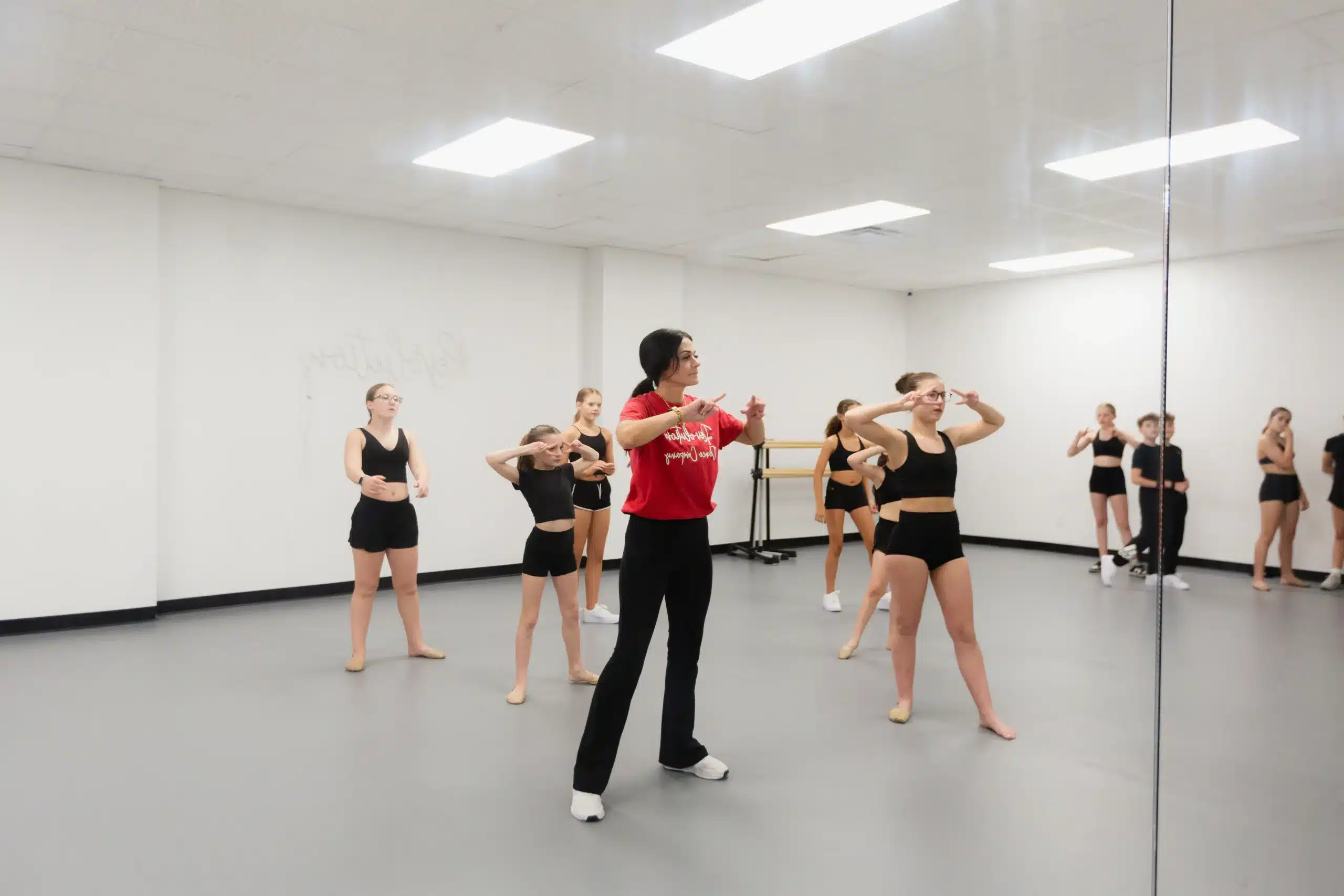 Dance instructor guiding students mirror practice